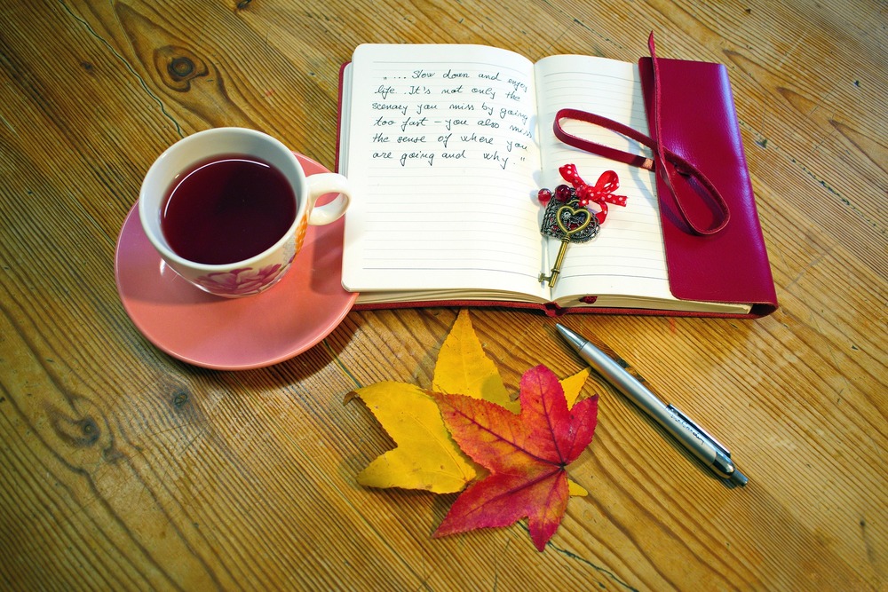 concepto viaje con cafe agenda y hojas de otoño